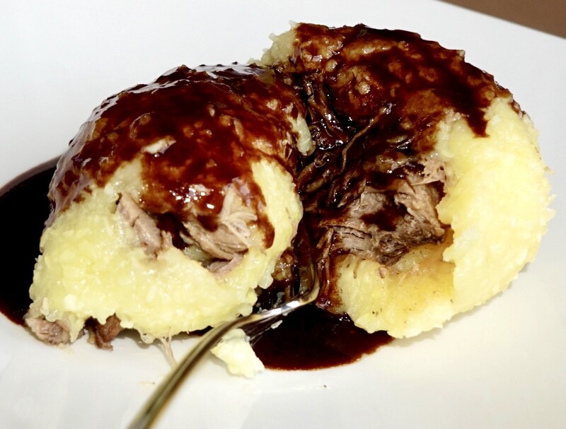 Schmidt’s Kloß XL nach dem Originalrezept von Koch Olaf Kranz: ein aufgebrochener, gefüllter Kartoffelkloß mit regionalem, zartem Fleischkern und dunkler Sauce aus der kreativen Küche Schmidt's in Dresden, Hellerau.