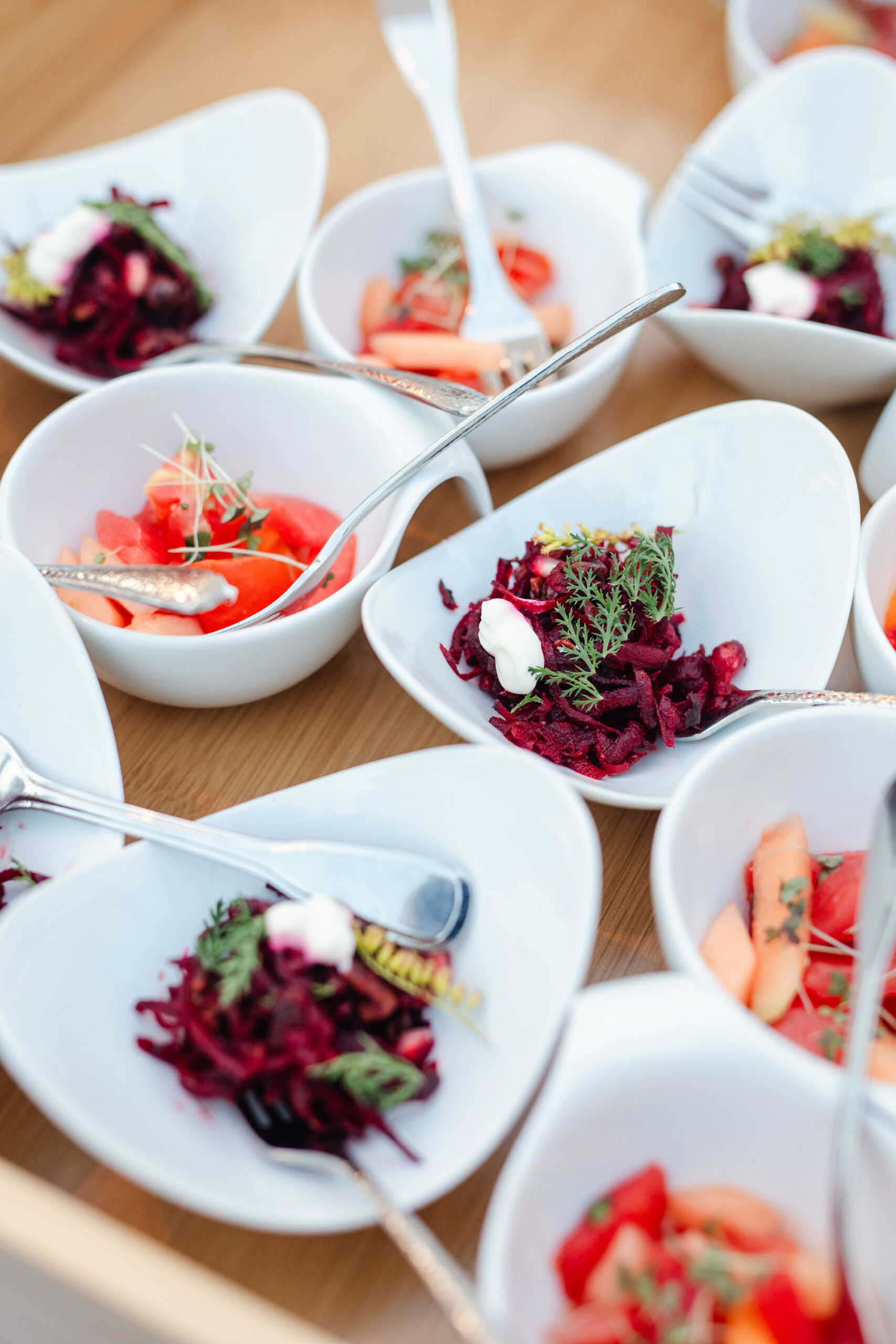 Kleine Leckerbissen und Fingerfood von Schmidts Catering stehen angerichtet auf einem Buffet.
