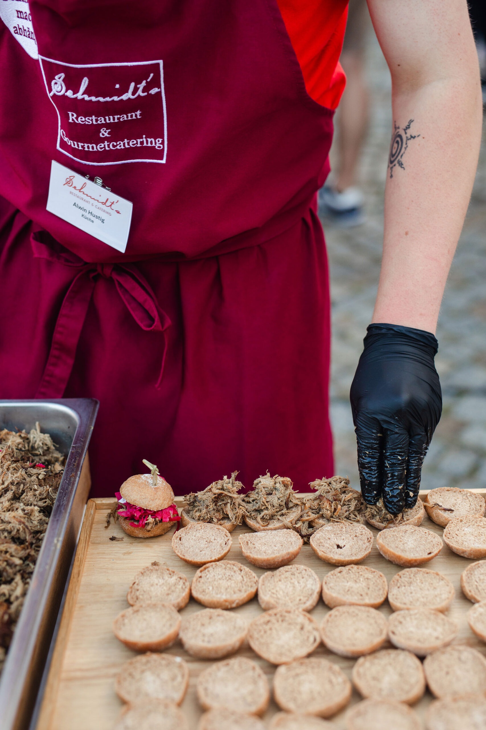 Eine Catering-Mitarbeiterin von Schmidts bereitet vor Ort frische und saisonale Leckerbissen vor.